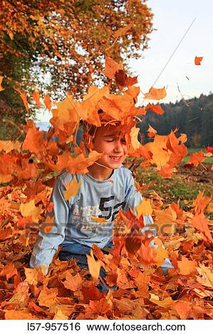 boy playing in pile of leaves, fall Zuerich, Switzerland View Large Photo Image Stock Photograph - boy playing in pile of leaves, fall Zuerich, Switzerland. Fotosearch