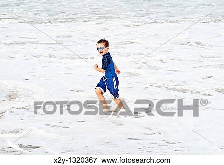 Boy playing in the ocean surf, Cape Cod, MA View Large Photo Image Stock Photo - Boy playing in the ocean surf, Cape Cod, MA. Fotosearch
