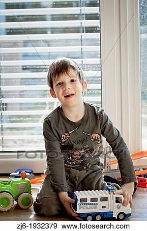 Stock Photo - Boy playing indoor with toy truck.. Fotosearch
