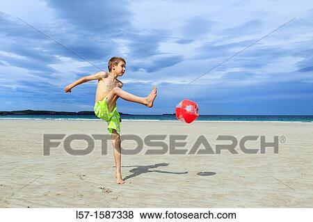 Stock Photo - boy playing on sandy beach, Sutherland, Scotland. Fotosearch