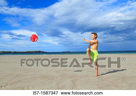 Stock Photo - boy playing on sandy beach, Sutherland, Scotland. Fotosearch