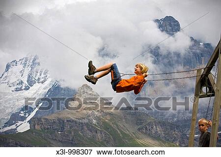 Boy playing on swing Switzerland View Large Photo Image Stock Photo - Boy playing on swing Switzerland. Fotosearch