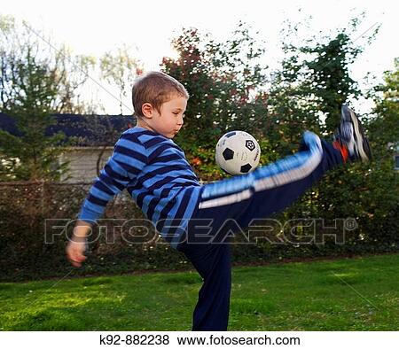 Boy playing soccer in his backyard. View Large Photo Image Stock Photo - Boy playing soccer in his backyard.. Fotosearch