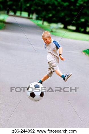 Boy playing soccer in park, summer, Krakow, Poland View Large Photo Image Stock Image - Boy playing soccer in park, summer, Krakow, Poland. Fotosearch