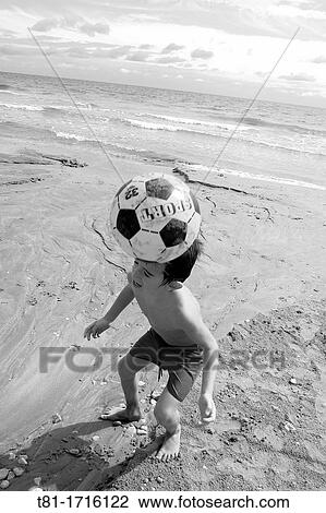 Boy playing soccer on the beach View Large Photo Image Stock Image - Boy playing soccer on the beach. Fotosearch
