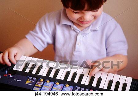 Stock Photograph - Boy playing the keyboard. Fotosearch