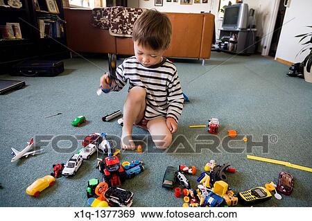Stock Photo - Boy playing with a toy hammer Inneruulalik Farm, South Greenland. Fotosearch