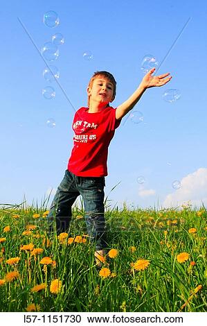 boy playing with bubbles in field of Dandelions, Zuercher Oberland, Zuerich, Switzerland View Large Photo Image Stock Image - boy playing with bubbles in field of Dandelions, Zuercher Oberland, Zuerich, Switzerland. Fotosearch