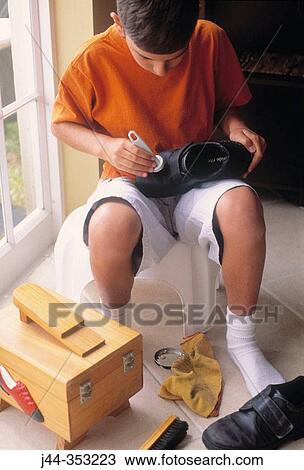 Boy polishing shoes in the house View Large Photo Image Stock Image - Boy polishing shoes in the house. Fotosearch