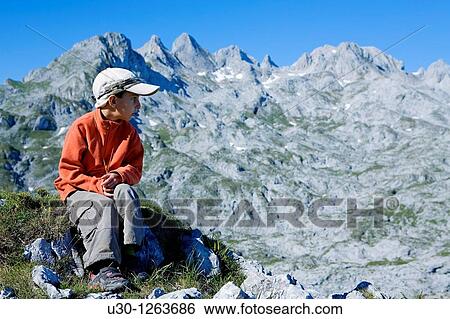 Stock Photograph - Boy practice mountaineering, in Vega de Ario, next to Marqu's de Villaviciosa Hut, in honor of Mr Pedro Pidal y Bernardo de Quir? s, known as Vega de Ario Hut, in the Corni? n massif, in Picos de Europa National Park, Asturias, Spain. Fotosearch