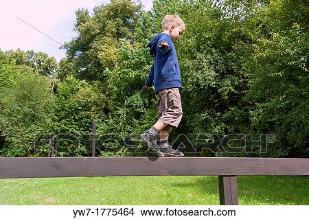 Boy practising on balance beam View Large Photo Image Picture - Boy practising on balance beam. Fotosearch