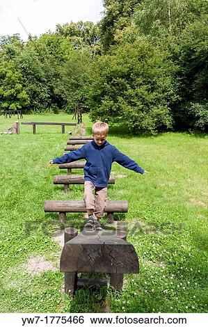 Stock Photograph - Boy practising on balance beam. Fotosearch
