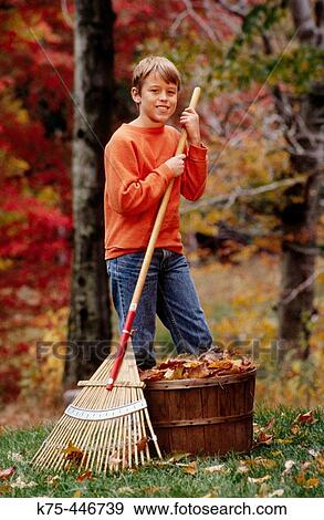 Stock Photo - boy raking leaves. Fotosearch