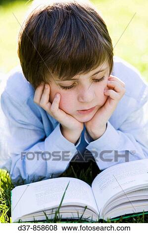 Boy reading a book in the garden View Large Photo Image Stock Photo - Boy reading a book in the garden. Fotosearch