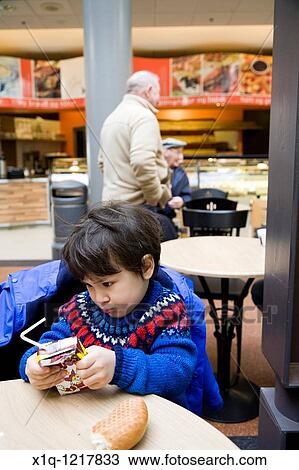 Stock Image - Boy refusing to eat his bagel Hafnarfjordur Iceland. Fotosearch