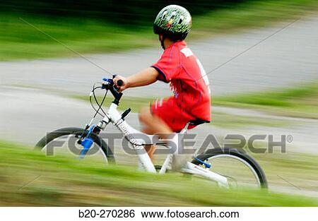 Boy riding a bicycle View Large Photo Image Stock Photograph - Boy riding a bicycle. Fotosearch