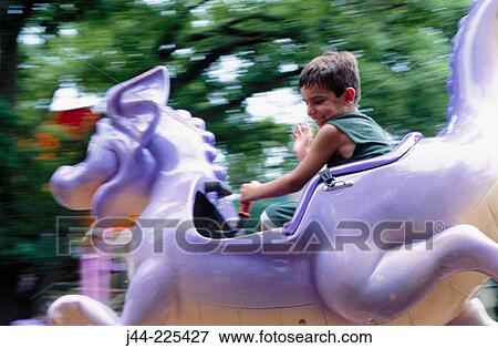 Boy riding a flying dragon in an amusement park View Large Photo Image Stock Photo - Boy riding a flying dragon in an amusement park. Fotosearch