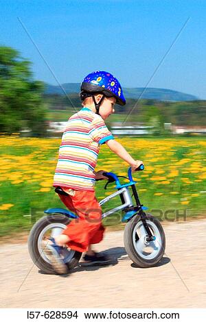 Picture - boy riding bicycle / Like a Bike, in spring, Gossau ZH, Zuerich, Switzerland. Fotosearch