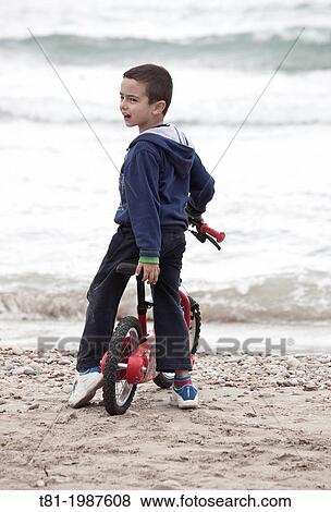 Boy riding bicycle on beach View Large Photo Image Stock Photo - Boy riding bicycle on beach. Fotosearch
