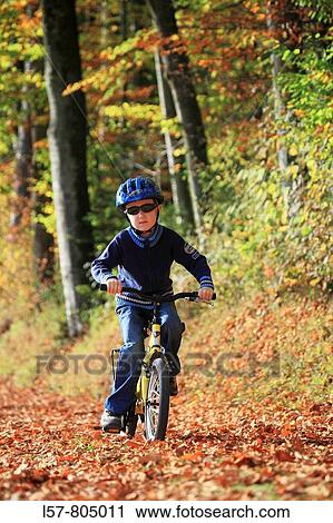 boy riding his bicycle on road with leaves in fall, autumn foliage covering path in forest, autumn, fall, Zuerich, Switzerland View Large Photo Image Stock Image - boy riding his bicycle on road with leaves in fall, autumn foliage covering path in forest, autumn, fall, Zuerich, Switzerland. Fotosearch