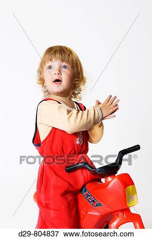 Stock Photo - BOY RIDING TOY TRICYCLE. Fotosearch