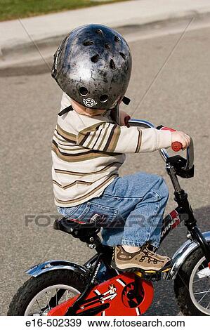 Boy riding tricycle View Large Photo Image Stock Photo - Boy riding tricycle. Fotosearch
