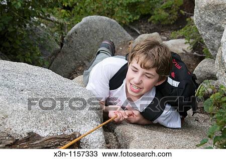 Stock Image - Boy rock climbing. Fotosearch