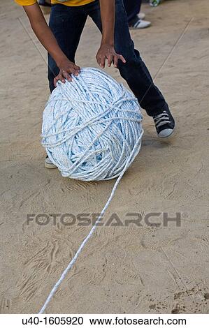Boy rolling a giant ball of string View Large Photo Image Stock Image - Boy rolling a giant ball of string. Fotosearch