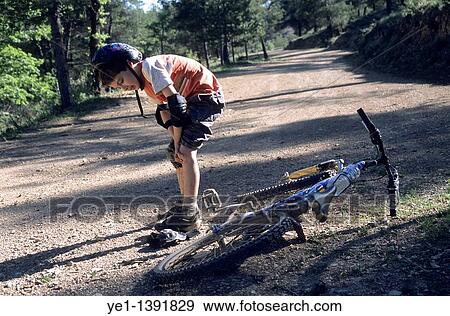 Boy rubbing his knee after falling off his bike, Vitrolles-en-Luberon, Provence, France View Large Photo Image Stock Photo - Boy rubbing his knee after falling off his bike, Vitrolles-en-Luberon, Provence, France. Fotosearch