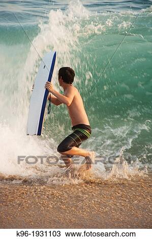 boy running from a big ocean wave View Large Photo Image Stock Image - boy running from a big ocean wave. Fotosearch