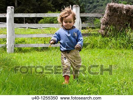 Boy running in field View Large Photo Image Stock Image - Boy running in field. Fotosearch