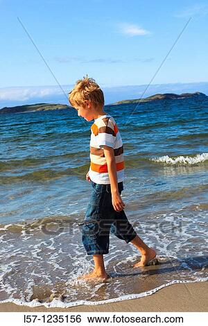 Stock Photograph - boy running on sandy beach, Sutherland, Scotland. Fotosearch