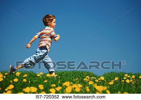 Boy running through filed of Dandelions, in spring, Switzerland. View Large Photo Image Stock Image - Boy running through filed of Dandelions, in spring, Switzerland.. Fotosearch