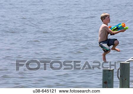 boy shooting water gun while jumping into the Albemarle Sound, North Carolina View Large Photo Image Stock Image - boy shooting water gun while jumping into the Albemarle Sound, North Carolina. Fotosearch