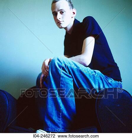 Stock Image - Boy sitting down in an armchair. Fotosearch