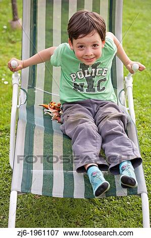 boy sitting on a a lounger. View Large Photo Image Stock Photo - boy sitting on a a lounger.. Fotosearch