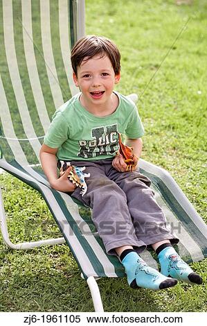 Stock Photography - boy sitting on a a lounger.. Fotosearch