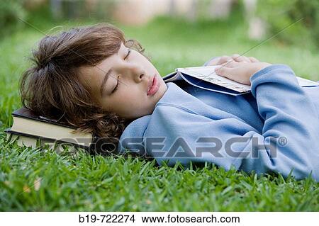 Picture - Boy sleeping laying on grass. Fotosearch