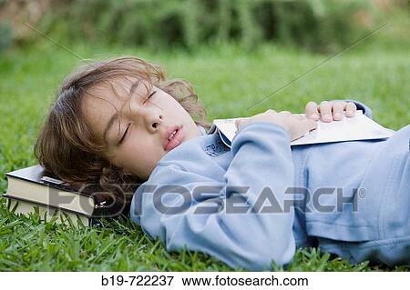 Stock Photo - Boy sleeping laying on grass. Fotosearch