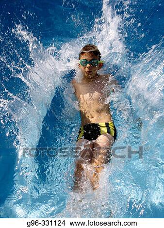 Picture - Boy splashing on swimming pool. Fotosearch