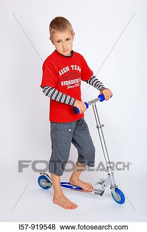 Stock Photo - boy standing on kickboard, kick scooter, white background, Studio, Switzerland. Fotosearch