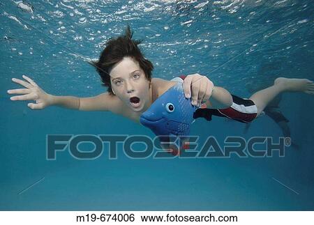 Boy swiming unnderwater with a fish View Large Photo Image Stock Photograph - Boy swiming unnderwater with a fish. Fotosearch