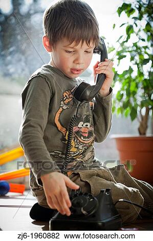 Stock Image - Boy using a retro telephone.. Fotosearch