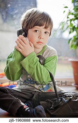 Stock Photo - Boy using a retro telephone.. Fotosearch