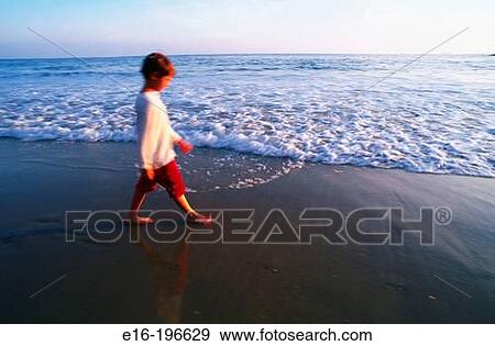 Boy walking on beach View Large Photo Image Stock Photo - Boy walking on beach. Fotosearch