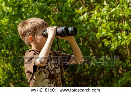 Boy watching birds through binoculars in a forest. View Large Photo Image Stock Image - Boy watching birds through binoculars in a forest.. Fotosearch