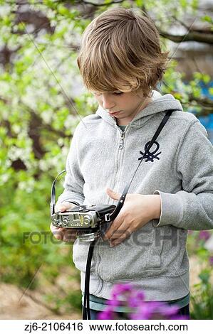 Stock Photograph - Boy with a old camera playing outdoors.. Fotosearch