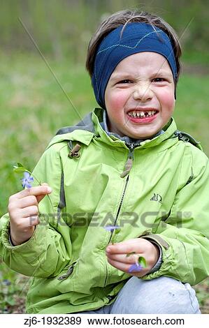 Boy with gap picking flowers early in the spring. View Large Photo Image Stock Photo - Boy with gap picking flowers early in the spring.. Fotosearch