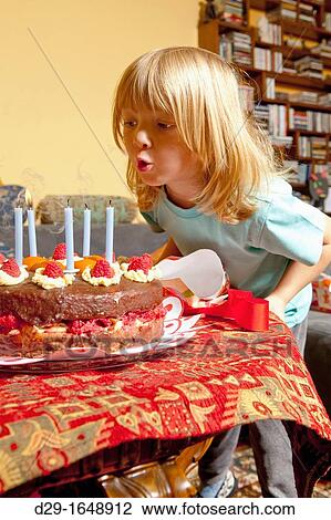 boy with long blond hair blowing out candles on his birthday cake View Large Photo Image Stock Image - boy with long blond hair blowing out candles on his birthday cake. Fotosearch