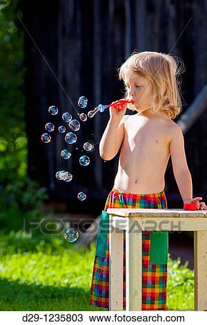 boy with long blond hair blowing soap bubbles View Large Photo Image Stock Image - boy with long blond hair blowing soap bubbles. Fotosearch